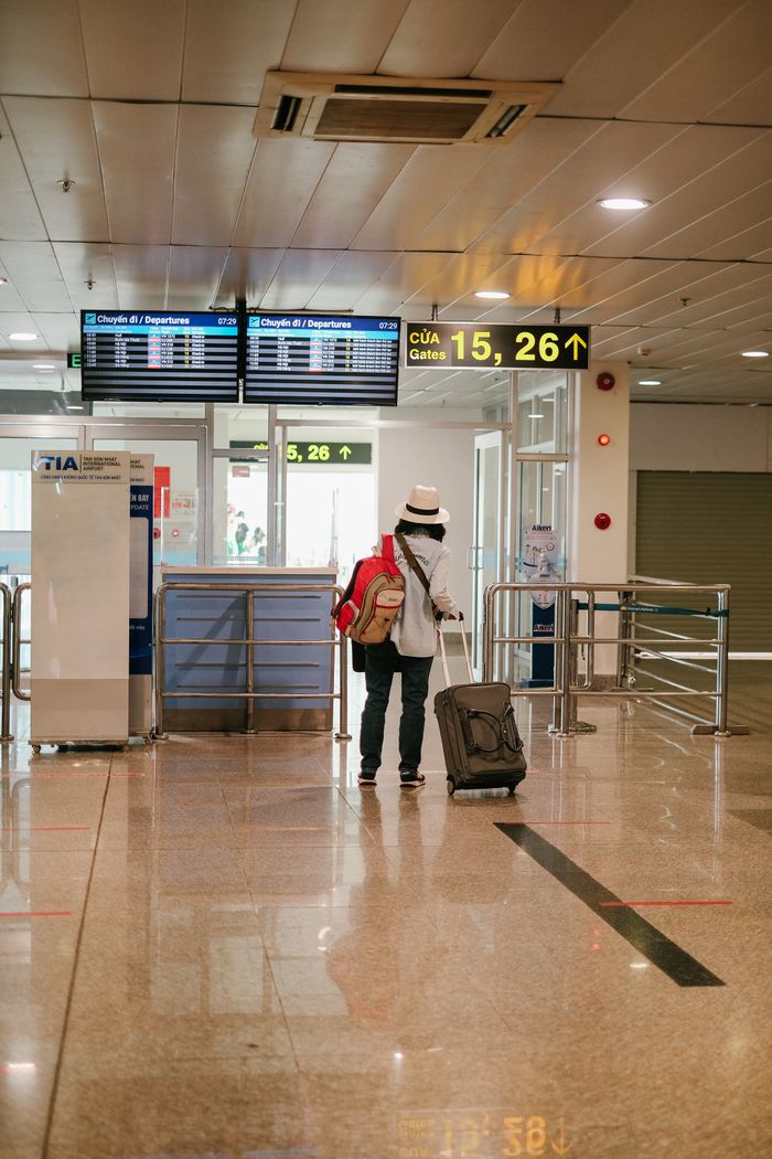 services-04 Woman with luggage exploring airport terminal. Solo travel and future adventures.