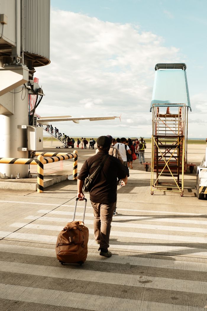 A man with luggage boarding a plane at Laguindingan Airport in the Philippines.